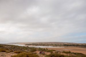 Bild einer nahezu ausgetrockneten Flusslandschaft mit einer kleinen Menschgruppe im Vordergrund