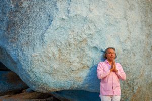 Portrait eines segnenden Mannes vor einem blauen Felsen in Tafraoute, in den Bergen des Antiatlas Gebirges in Marokko