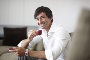 Entspannter Mann genießt seinen Kaffe auf seiner Couch