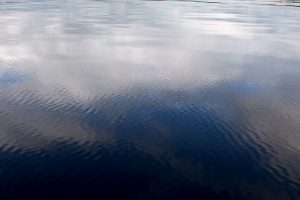 Bild einer ruhigen, glatten und spiegelnden Wasseroberfläche