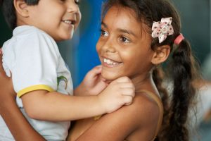 Bild einer brasilianischen Schülerin die mit einem kleinen Jungen trollt