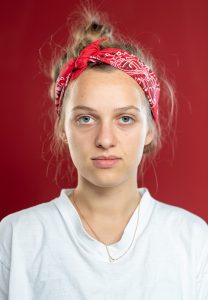 Portraitfoto einer jungen Frau mit rotem Haarband