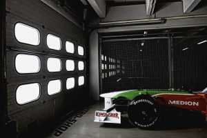 Formel 1 Rennwagen lauert hinter Garagentor